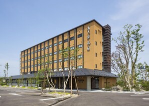 Un hôtel à plusieurs étages, doté d’une façade jaune et d’un design moderne.