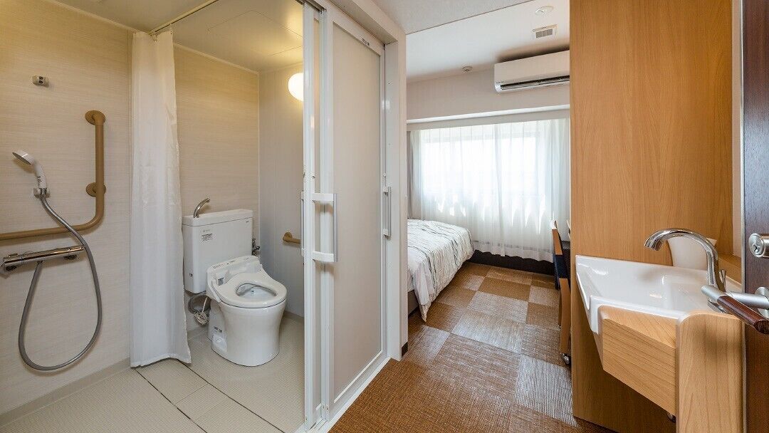 Un baño de hotel con inodoro, ducha y lavamanos.