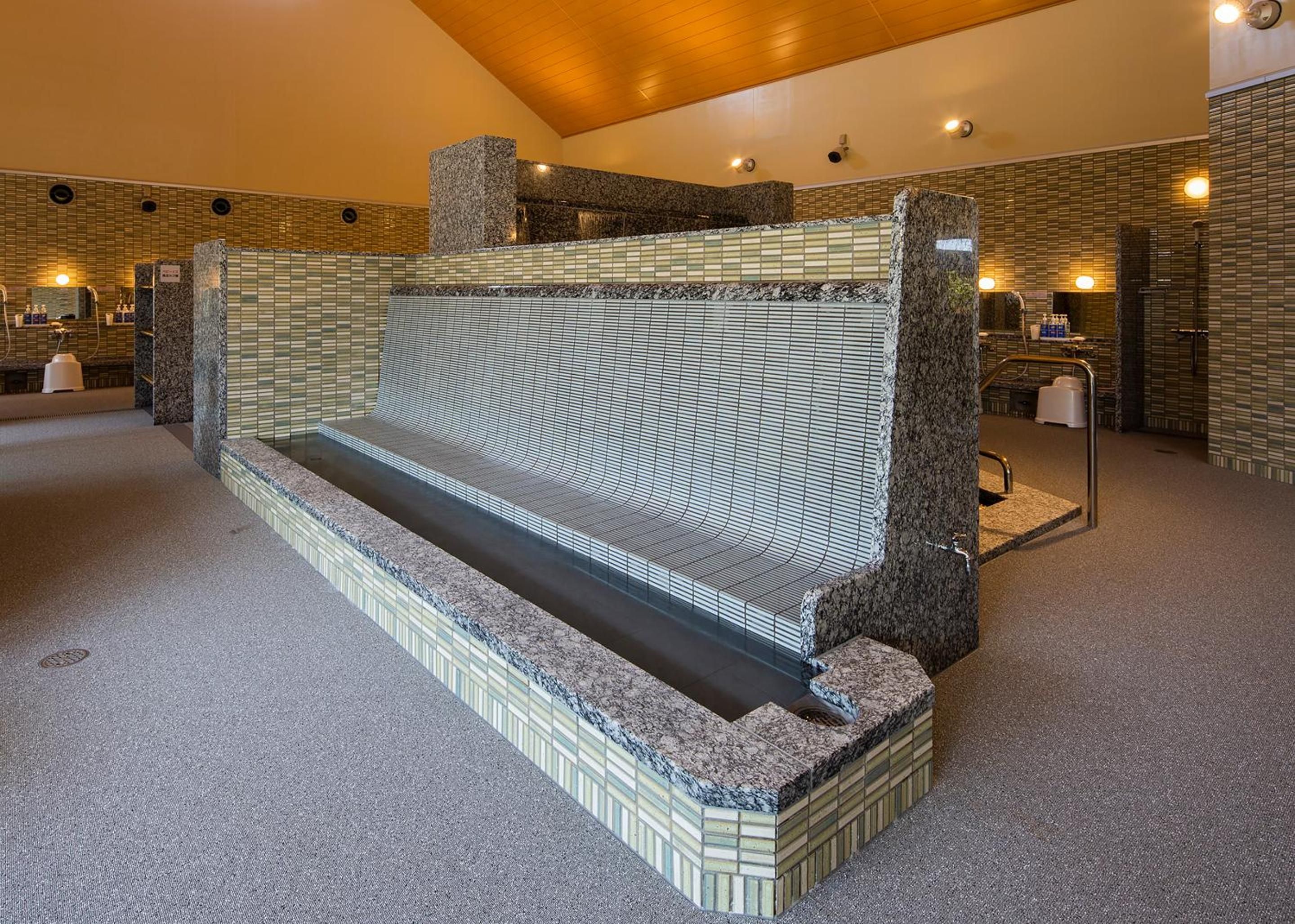 A spa area with a seating area, a water feature, and a reception desk.
