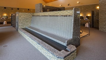 A spa area with a seating area, a water feature, and a reception desk.