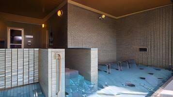 A modern interior with a pool area, featuring a unique brick wall design and a clear glass barrier.
