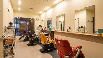 A hair salon with multiple chairs, mirrors, and a counter with various hairdressing tools.