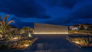 Un bâtiment moderne doté d’une façade en béton et d’un chemin pavé menant à l’entrée.