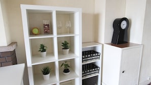 A white shelving unit with potted plants and wine glasses. - Seaviewcourt Kobe (Kobe)