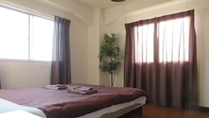 A hotel room with a bed, a plant, and curtains. - Seaviewcourt Kobe (Kobe)