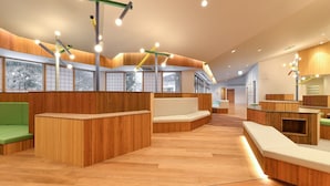 Un interior moderno con paneles de madera, zonas de estar y ventanas amplias.