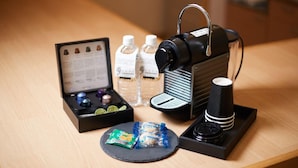 A table with a camera, a cup, bottled water, and snack packets. - Adan Resort Yuhina (Motobu)