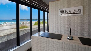 Mostrador de recepción en el Adan Resort con vistas a la playa y al océano.