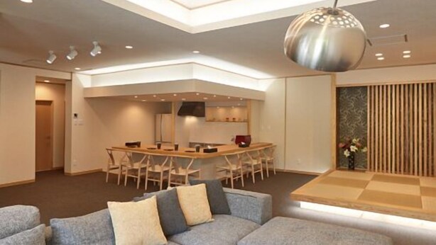 Un interior moderno con un sofá modular, una zona de comedor y un diseño de techo único.