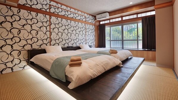 Une chambre de style japonais traditionnel, avec un sol recouvert de tatamis, un lit bas et un paravent de type shoji.