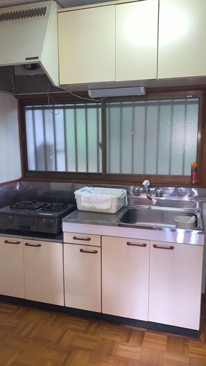 A kitchen with a gas stove, a sink, and cabinets. - Cottage Karuizawa (Karuizawa)