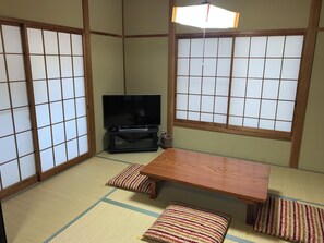 A traditional Japanese room with tatami flooring, a low wooden table, cushions, and a television. - Cottage Karuizawa (Karuizawa)