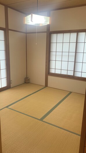 Una habitación tradicional japonesa con suelo de tatami, paneles shoji y una puerta corredera.