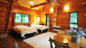 Een houten blokhut met twee bedden, een eettafel en een open haard.