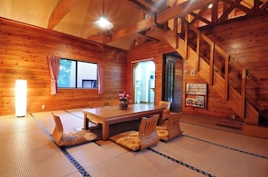 A wooden interior with a dining area, tatami mats, and a staircase. - Nabekura Kogen Mori no Ie (Iiyama)