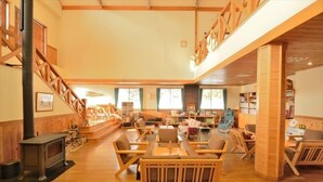 Une pièce spacieuse avec un escalier en bois, une cheminée et un coin repas doté de meubles en bois.