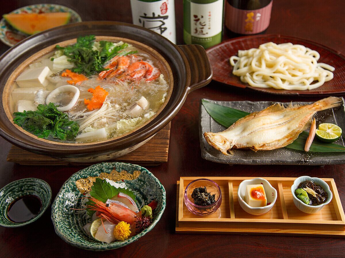 En traditionell japansk måltid med en gryta som tillagas vid bordet, sashimi och olika tillbehör.