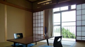 A traditional Japanese room with tatami flooring, a low table, and a sliding door. - Kiemonso (Shimoda)