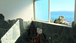 A stone wall with a window overlooking a coastal view. - Kiemonso (Shimoda)