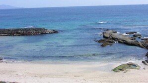 A beach with clear blue water, rocky outcrops, and a sandy shore. - Kiemonso (Shimoda)
