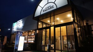 A building with a large illuminated sign reading "TAKAMI". - Business Hotel Takami (Minamisoma)