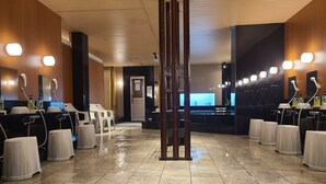 A clean, modern hair salon with multiple stations, each equipped with a chair, mirror, and hair washing station. - Business Hotel Takami (Minamisoma)