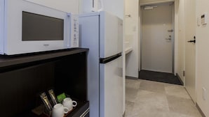 Une petite cuisine équipée d’un four à micro-ondes, d’un petit réfrigérateur et d’une machine à café.