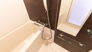 A bathroom with a bathtub, a shower, and a mirror. - Mr. Kinjo in Mihara (Naha)
