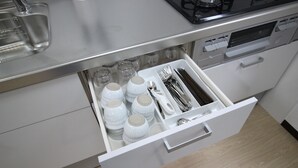 A kitchen drawer with white storage containers, utensils, and a stainless steel sink. - Akizero Onnason (Onna)