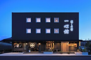 A modern building with a dark facade, multiple windows, and illuminated signage. - Funaya no Yado Wako (Kanoya)