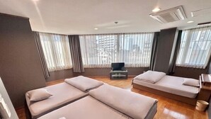 A modern hotel room with a large bed, a smaller sofa, and a television. - Maria Hotel (Utsunomiya)