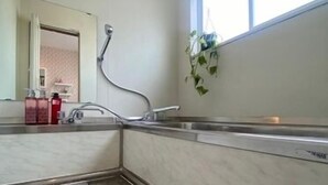 A bathroom with a tiled floor, a sink, a mirror, and a window. - Maria Hotel (Utsunomiya)