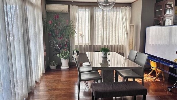 A modern living room with a dining table, chairs, a bench, and potted plants. - Maria Hotel (Utsunomiya)