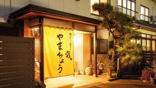A traditional Japanese building with a wooden entrance and a yellow sliding door. - Sakana Asobi No Yado Yamacho (Fukui)