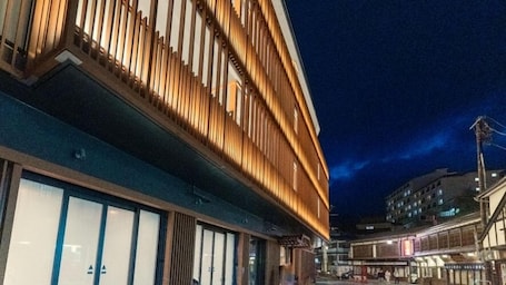 A traditional Japanese building with wooden slats and a tiled entrance.
