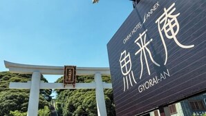 A sign for Gyorai Hotel with a traditional Japanese torii gate in the background.
