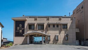 A hotel with a modern facade, a prominent entrance with a curved overhang, and signage indicating it is the GYORAI HOTEL ANNEX.