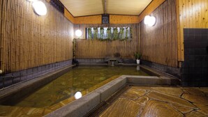 Interior de madeira com piscina central, bancos e um vaso de planta.