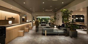 A modern interior with a reception desk, seating area, and dining space. - Aurum Misawa (Misawa)