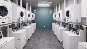 A laundry facility with multiple washing machines and dryers arranged in rows. - Aurum Misawa (Misawa)