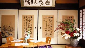 A traditional Japanese room with tatami flooring, a low wooden table, and a sliding door with calligraphy.