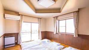Een hotelkamer met een bed, een verwarming en een raam met gordijnen.