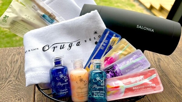 Una bandeja con artículos de aseo personal, incluyendo champú, gel de baño y una toalla con la marca 'Orugajares'.