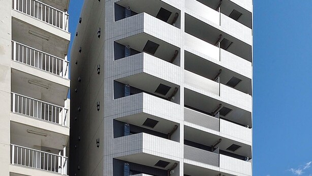 Un edificio moderno de varios pisos con fachada uniforme y balcones en cada planta.