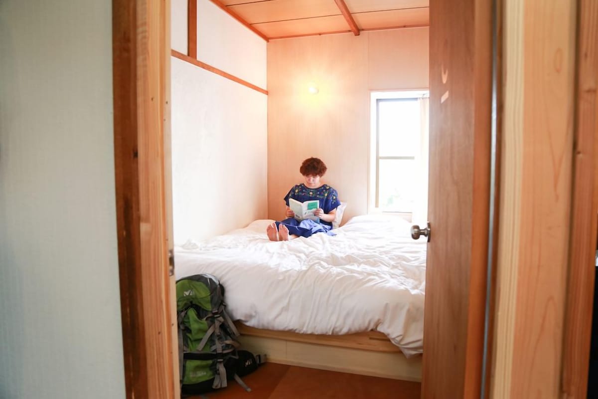 A room with a bed, a window, and a door.