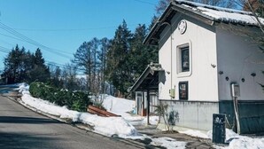 Yhden kerroksen talo, jonka ulkoseinät ovat valkoiset ja jossa on pieni kuisti.