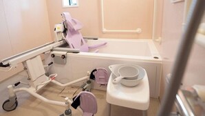 Ein Behandlungsraum mit einem Dentalstuhl, einem Waschbecken und einem kleinen Tisch mit einer Schüssel.