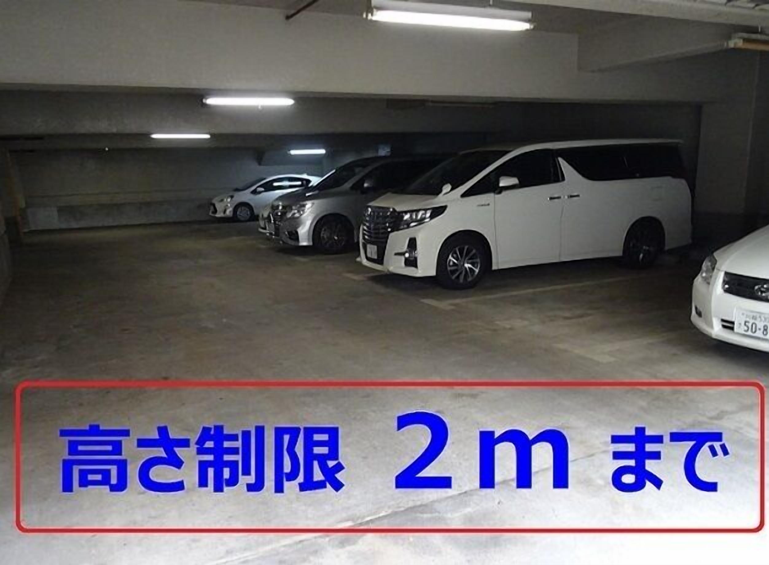 A parking garage with several white cars parked in rows.