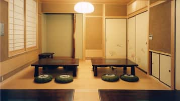 Ein traditioneller japanischer Raum mit Tatami-Böden, einem niedrigen Tisch und verschiebbaren Türen.