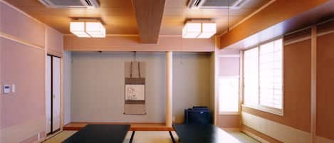 Una habitación con esteras de tatami, un celosía japonesa y una mesa baja de tatami.